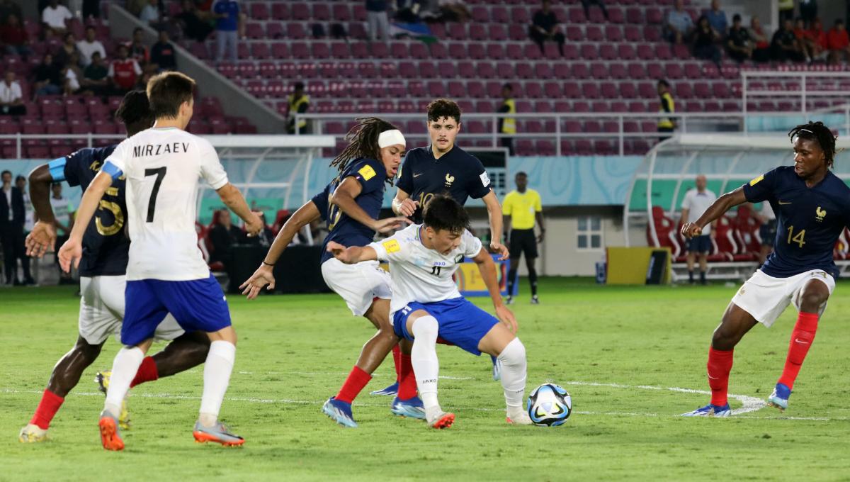 Gelandang Perancis, Mathis Amougou, mengawal ketat gelandang Uzbekistan, Kuvonchbek Abraev, dalam pertandingan babak 8 besar Piala Dunia U-17 2023 di Stadion Manahan Solo, Sabtu (25/11/23). Foto: Nofik Lukman Hakim