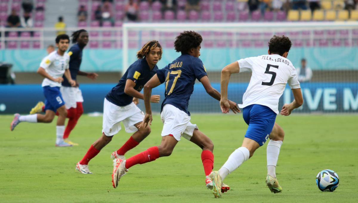 Gelandang Perancis, Tidiane Diallo, mengejar bola yang dikuasai bek Uzbekistan, Azizbek Tulkunbekov, dalam pertandingan babak 8 besar Piala Dunia U-17 2023 di Stadion Manahan Solo, Sabtu (25/11/23). Foto: Nofik Lukman Hakim