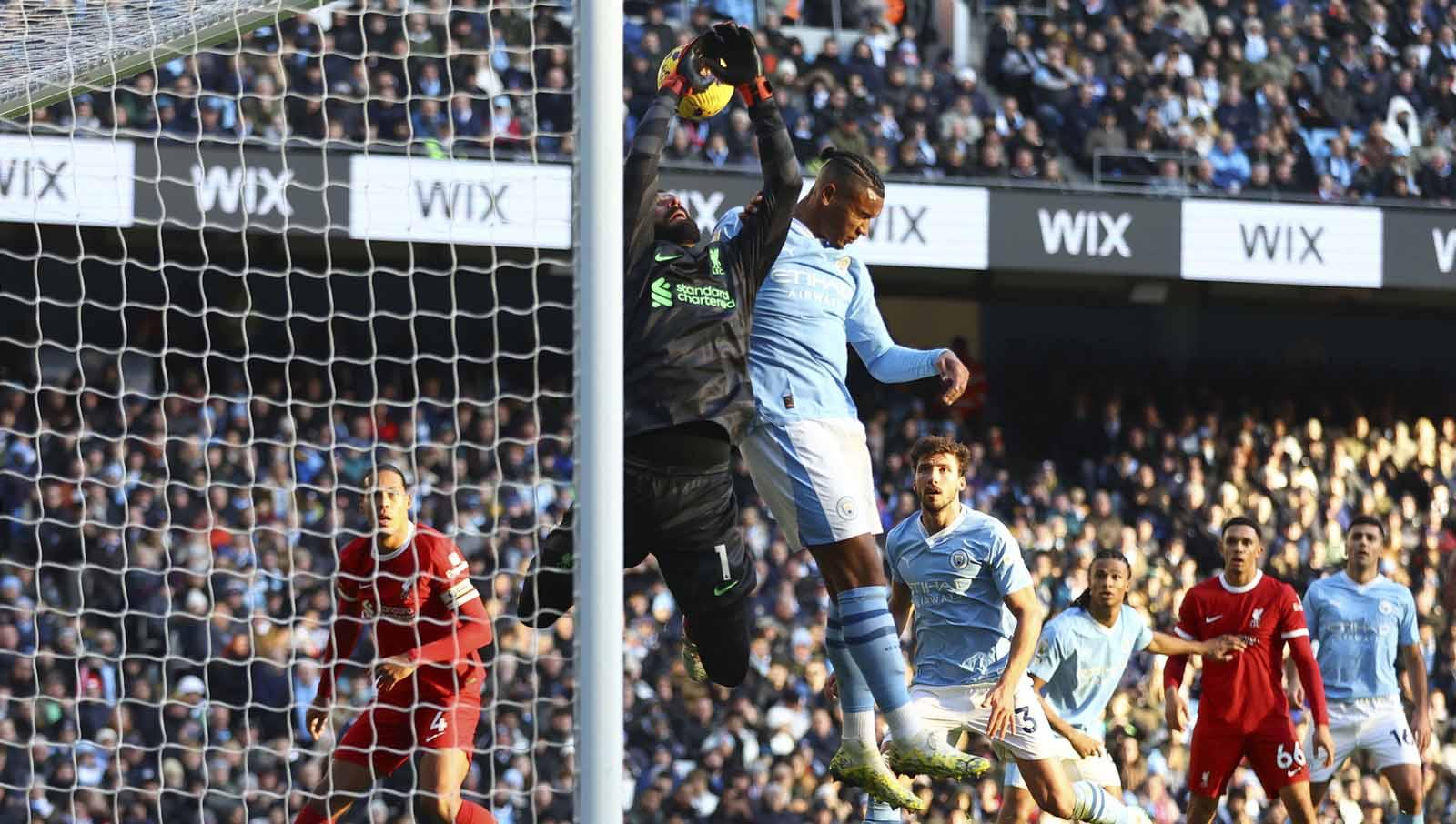 Manuel Akanji berduel dengan kiper Alisson yang sebelum Ruben Dias mencetak gol yang kemudian dianulir pada laga Liga Primer Inggris, Sabtu (25/11/23). (Foto: REUTERS/Carl Recine)