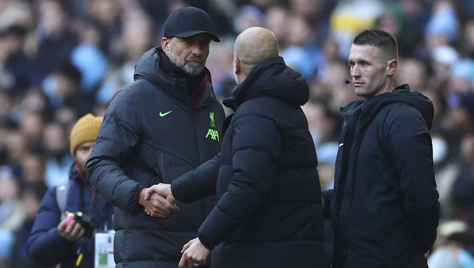 Pelatih Liverpool Juergen Klopp saat berjabat tangan dengan pelatih Manchester City Pep Guardiola usai pertandingan pada laga Liga Primer Inggris, Sabtu (25/11/23). (Foto: REUTERS/Carl Recine)