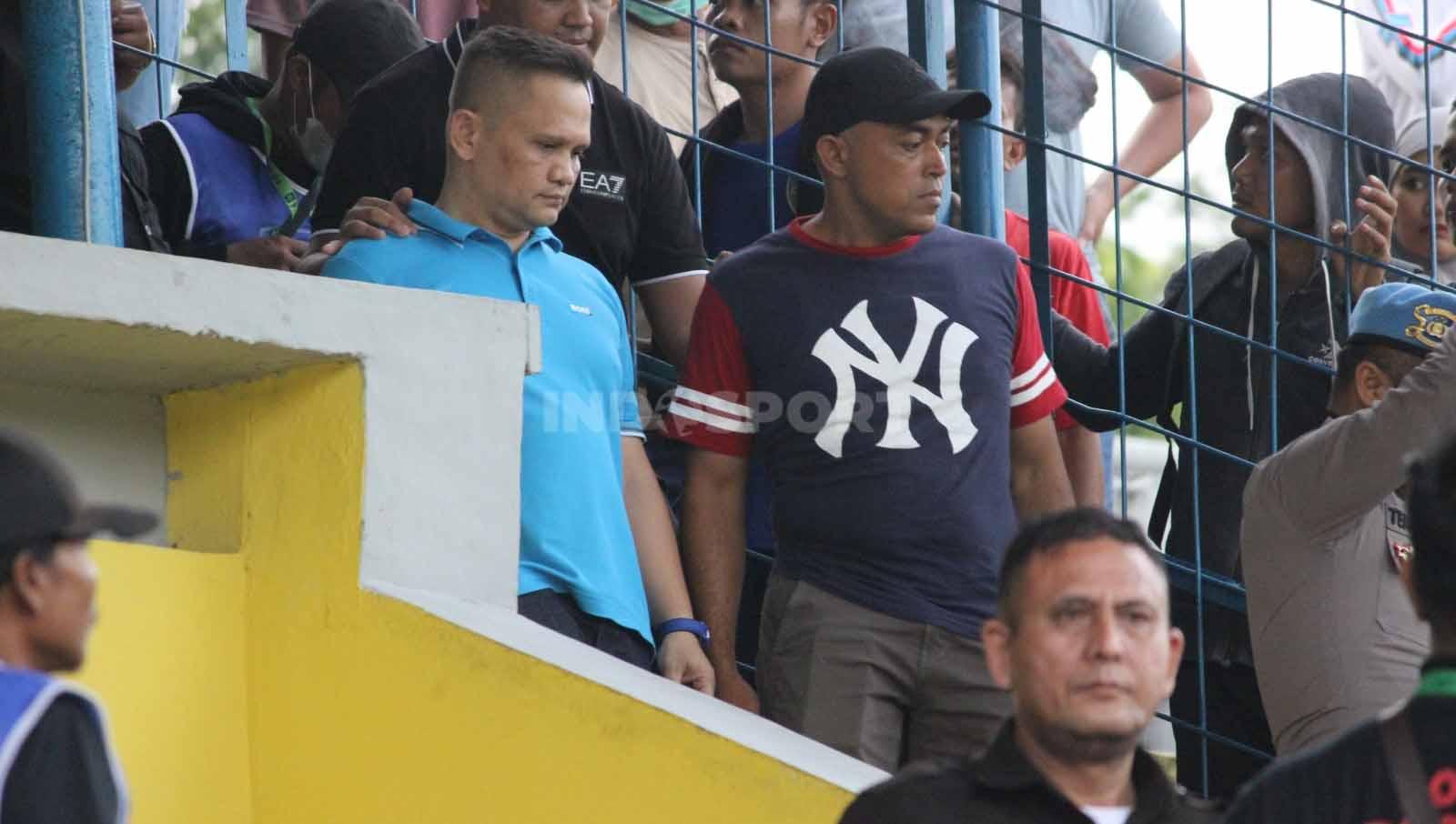Nazaruddin Dek Gam (baju biru) dikawal pihak keamanan saat meninggalkan stadion. (Foto: Aldi Aulia Anwar/INDOSPORT)