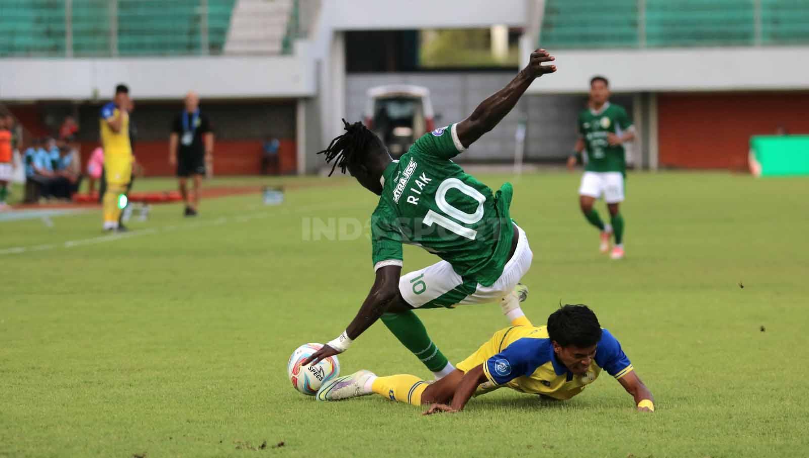 Duel bek Barito Putera, Buyung Ismu, dengan penyerang jangkung PSS Sleman, Ajak Riak, dalam laga pekan ke-20 Liga 1 2023-2024 di Stadion Maguwoharjo Sleman, Minggu (26/11/23). (Foto: Nofik Lukman Hakim/INDOSPORT) - INDOSPORT