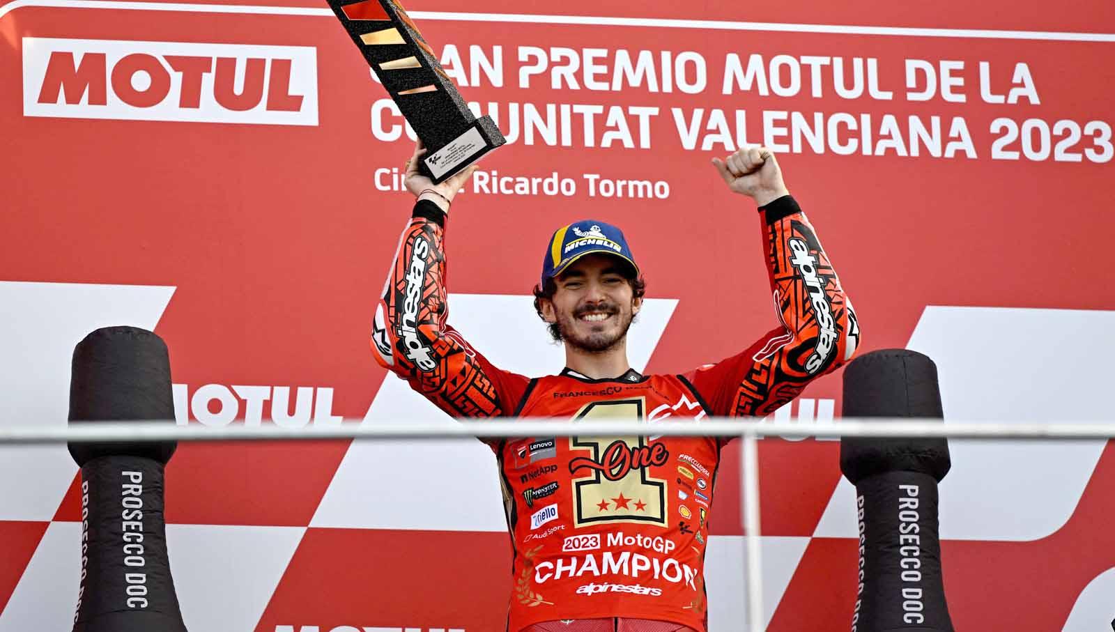 Francesco Bagnaia angkat tropi di podium usai memenangkan balapan Kejuaraan Dunia MotoGP di Sirkuit Recardo Tormo, Valencia, Spanyol, Minggu (26/11/23). (Foto: REUTERS/Pablo Morano) - INDOSPORT