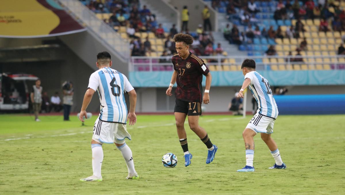 Bek Jerman, Eric Da Silva Moreira, berusaha melewati kawalan bek Argentina dalam pertandingan semifinal Piala Dunia U17 2023 di Stadion Manahan Solo, Selasa (28/11/23). Foto: Nofik Lukman Hakim