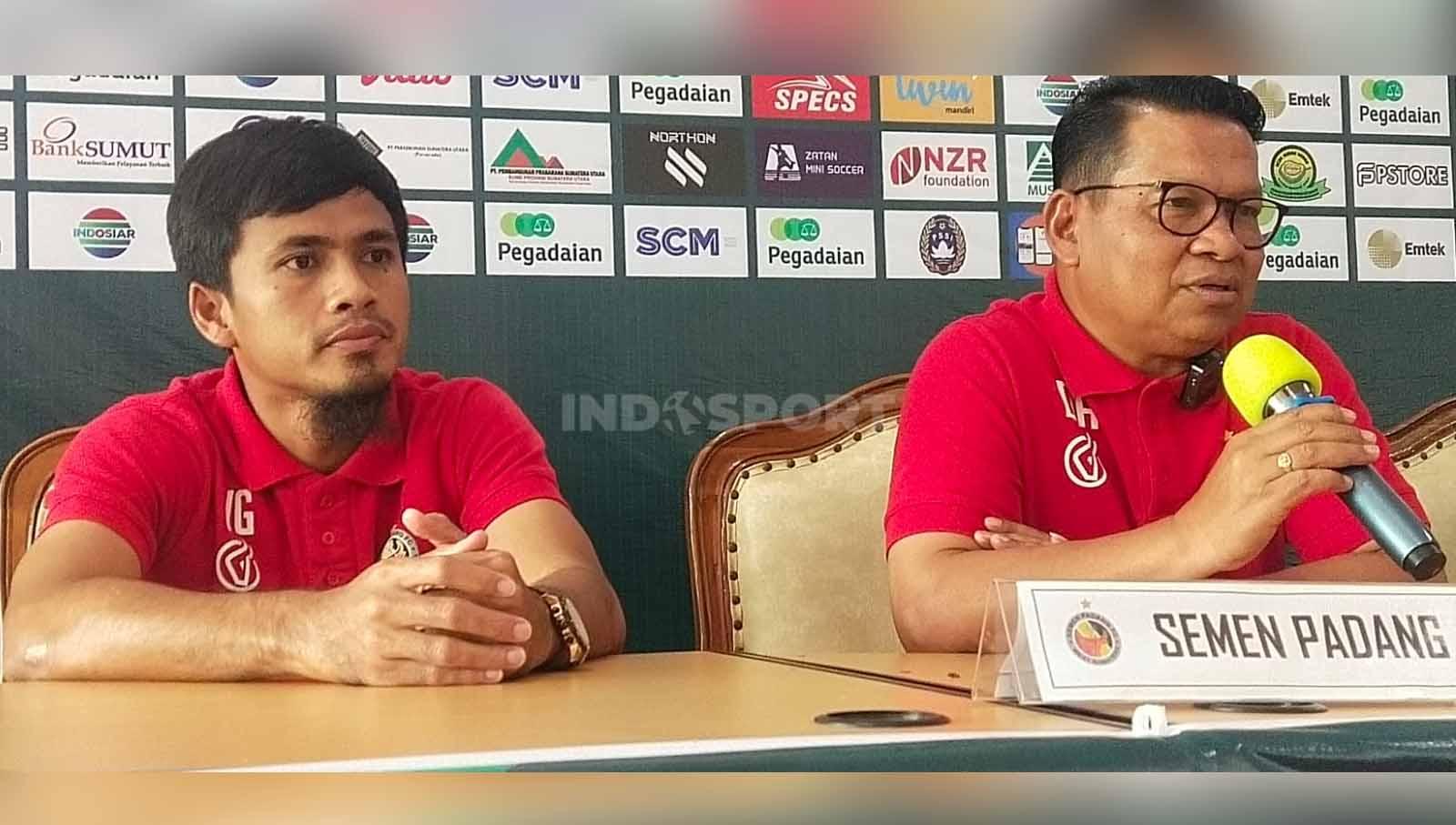 Pelatih Semen Padang, Delfiadri (kanan), didampingi pemainnya, Wiganda Pradika (kiri) dalam temu pers jelang laga melawan PSMS Medan. (Foto: Aldi Aulia Anwar/INDOSPORT)