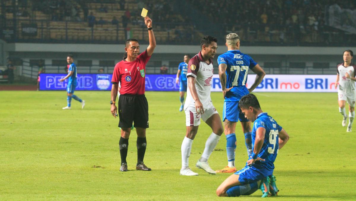 Wasit Gedion Dapaherang, memberikan kartu kuning untuk pemain PSM Makassar, Safrudin Tahar saat menghadapi Persib Bandung pada pertandingan pekan ke-21 di kompetisi Liga1 2023-2024 di Stadion Gelora Bandung Lautan Api (GBLA), Kota Bandung, Senin (04/12/23