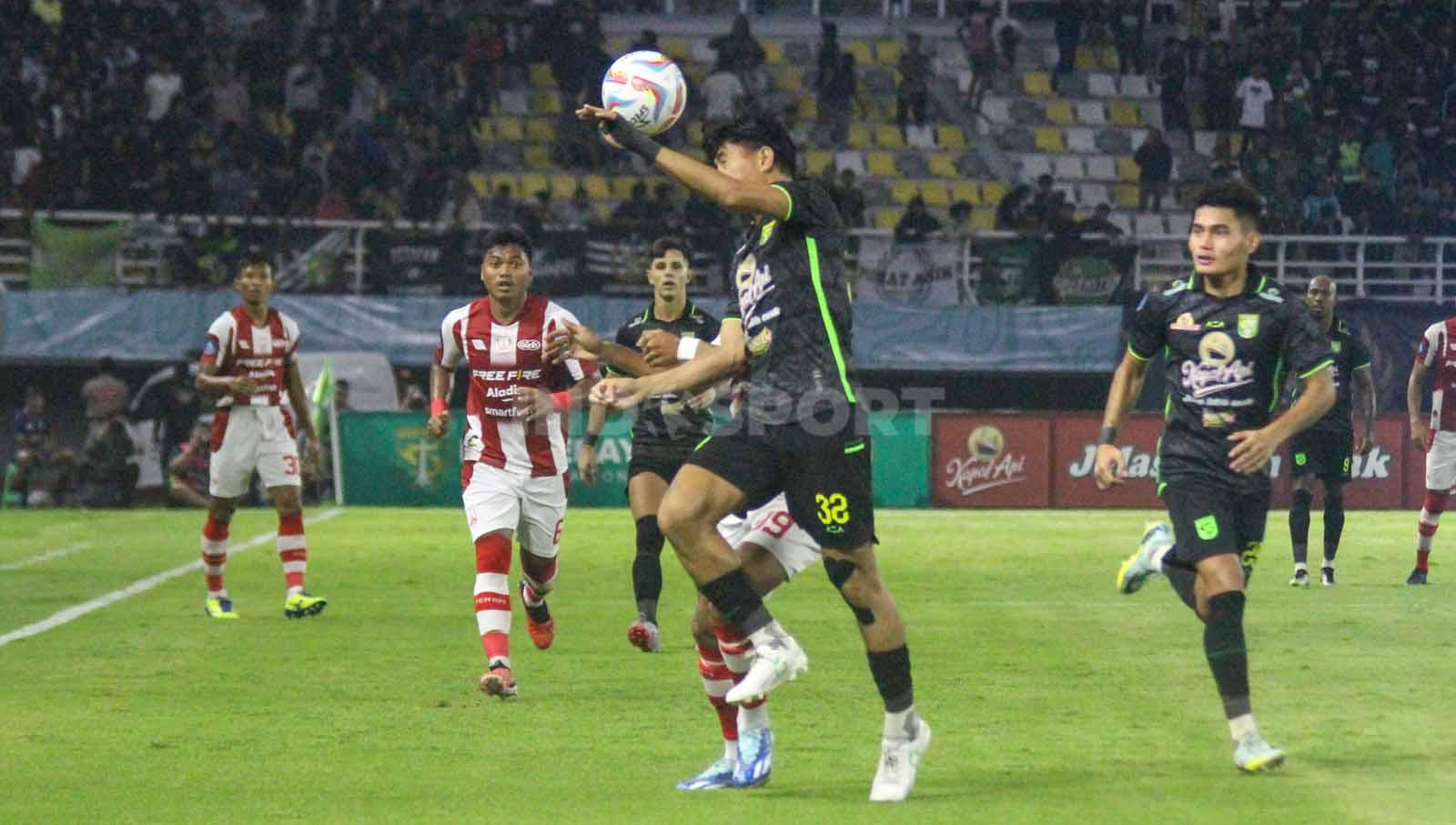 Riswan Lauhin saat berduel dengan pemain Persis Solo untuk berebut bola pada laga Liga 1 di Stadion di Gelora Bung Tomo, Rabu (13/12/23). (Foto: Fitra Herdian/INDOSPORT)