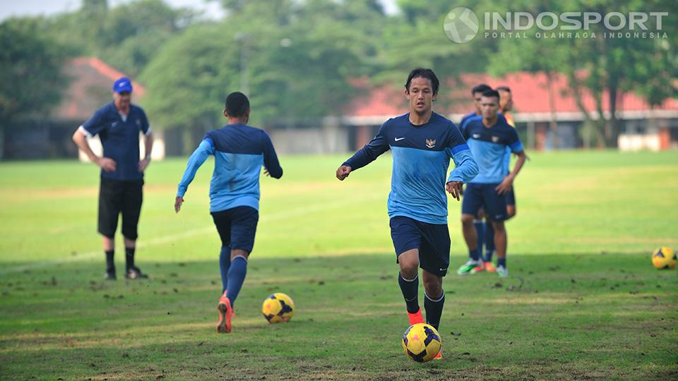 Alfred Riedl mengawasi Irfan Bachdim menggiring bola dari kejauhan dalam latihan di lapangan Sekolah Pelita Harapan, Karawaci, Tangerang, Senin (07/07/14). 