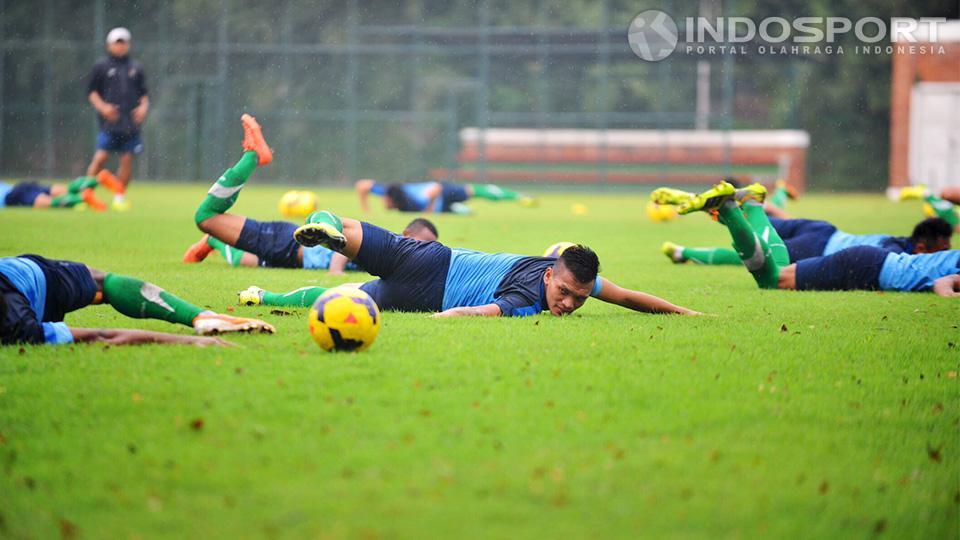 Ferdinand Sinaga berbaring melakukan peregangan saat latihan di lapangan Sekolah Pelita Harapan, Karawaci, Tangerang, Senin (07/07/14).