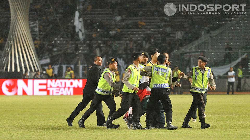 Seorang fans Juventus diamankan oleh polisi setelah berlari ke tengah lapangan Stadion Utama Gelora Bung Karno, Jakarta, Rabu (06/08/14).