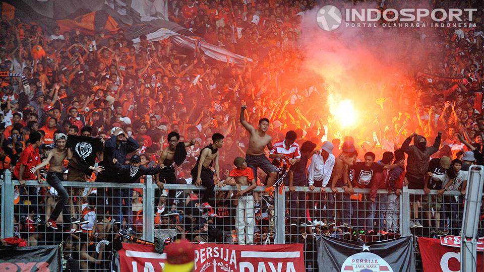 Jakmania terus memberi dukungan dengan bernyanyi dan membakar flare. 