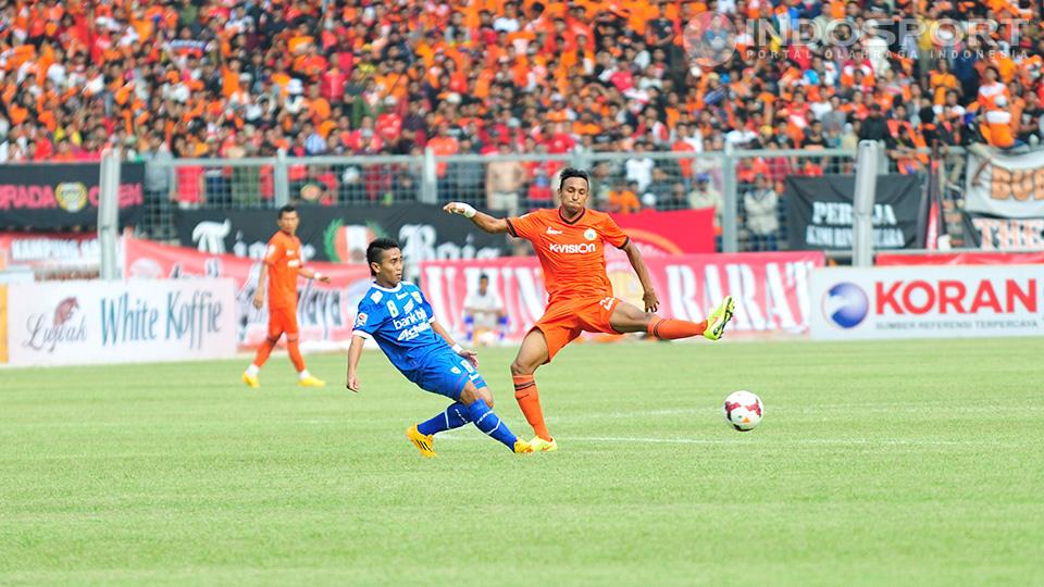 Pemain Persib M. Taufik berusaha keras menghalau gempuran pemain Persija. 