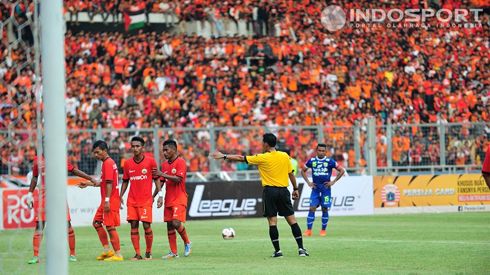 Wasit mengatur para pemain Persija sementara pemain Persib Firman Utina bersiap mengambil tendangan bebas pada pertandingan Persija vs Persib di GBK, Minggu (10/08/14). Copyright: Ratno Prasetyo/ INDOSPORT