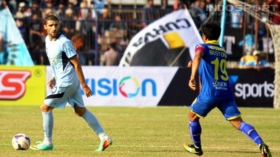 Playmaker Persela Lamongan, Srdan Lopicic (kiri), menguasai bola dengan dikawal gelandang Arema Cronus, Ahmad Bustomi, dalam laga 8 besar ISL 2014 di Stadion Surajaya, Lamongan, Rabu (08/10/14). Partai itu berakhir 2-2.