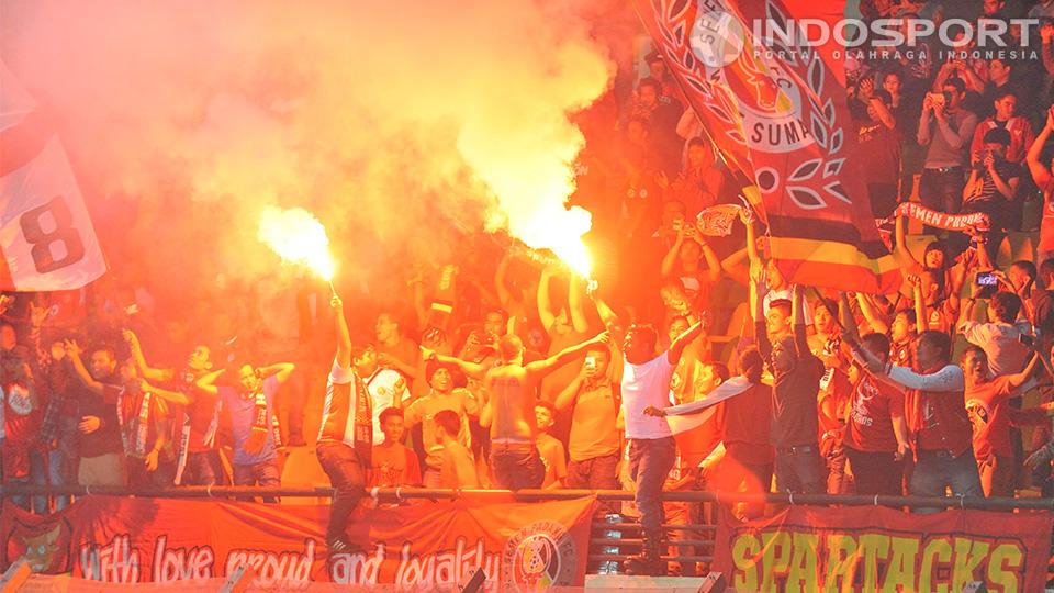 Suporter Semen Padang menyalakan flare setelah memastikan klub kesayangan menjadi pemenang Liga Super U-21 musim kompetisi 2013-14 berkat kemenangan 4-0 atas Sriwijaya di Kabupaten Bandung.