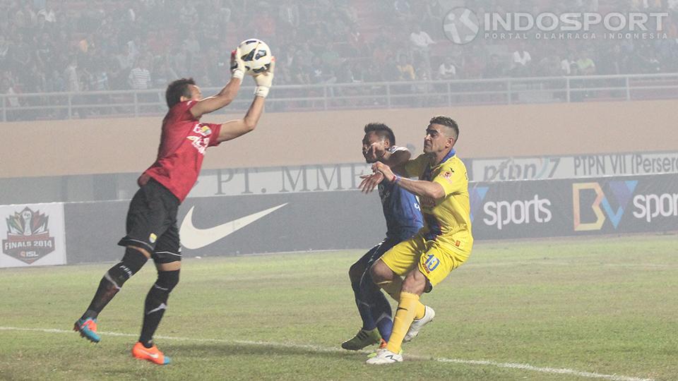 Kiper Persib Bandung I Made Irawan dengan sigap menangkap bola dari hasil serangan Arema Cronus. 