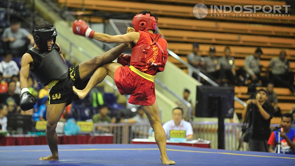 Huong Dinh Van (baju hitam) melancarkan tendangan ke arah kepala atlet wushu Indonesia Edowar Virnanda (merah) pada kelas 52 kg Kejuaraan Sanda Wushu VII 2014 di Istora Senayan, Jakarta, Kamis (20/11/14).