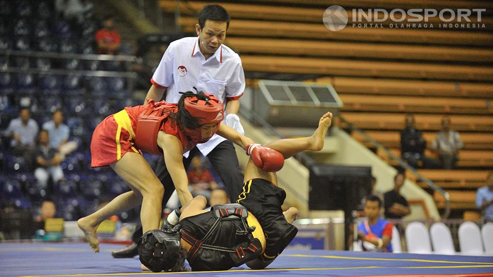 Atlet wushu Vietnam Chinh Nguyen Tinh (kiri) berhasil merobohkan atlet wushu Indonesia Junita Malau di kelas 48 kg putri.