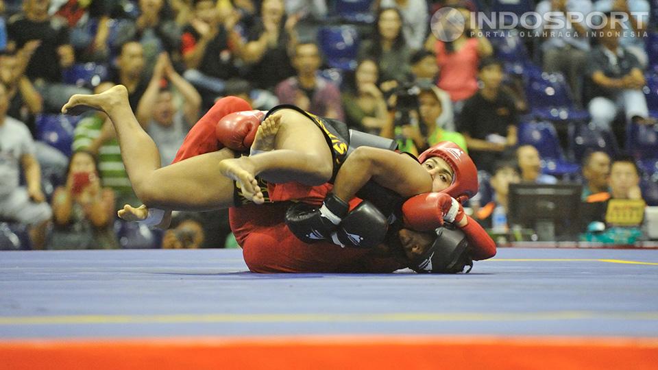 Pewushu Iran Maryam Hashemiforoud (bawah) berhasil mengunci Moria Manalu di kelas 65 kg wanita.