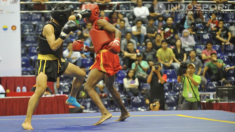 Edowar Virnanda (hitam) berhasil melayangkan pukulan telak ke atlet wushu India (merah) Santosh Kumar pada kelas 52kg. 