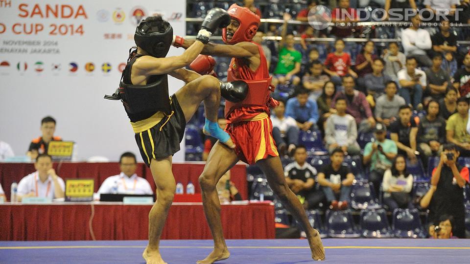 Edowar Virnanda (kiri) menahan pukulan pewushu India Santosh Kumar.