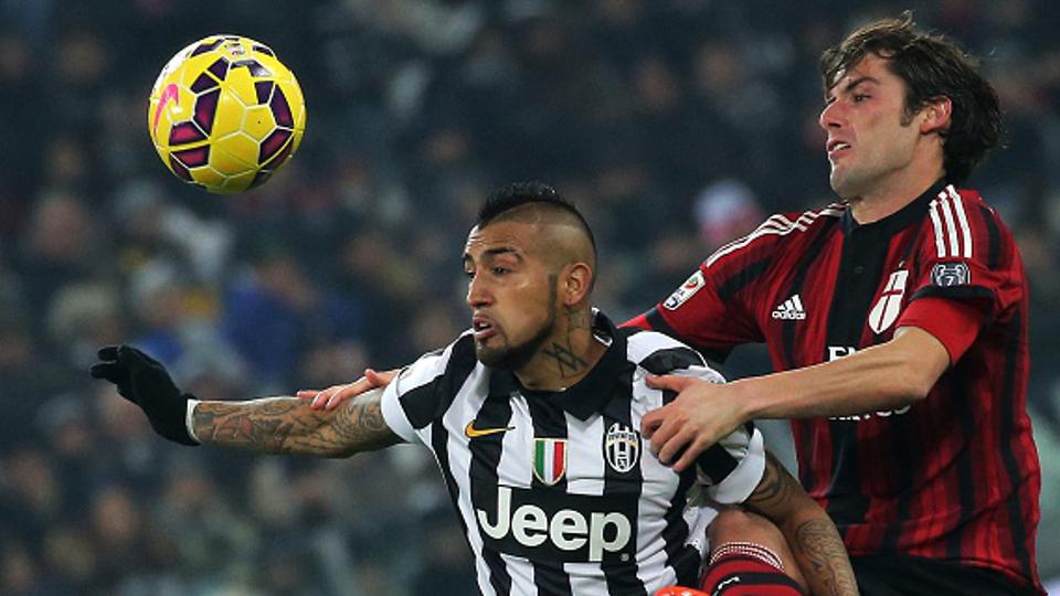 Gelandang serang Juventus Arturo Vidal melakukan duel udara dengan pemain AC Milan Andrea Poli. Copyright: GETTY IMAGES