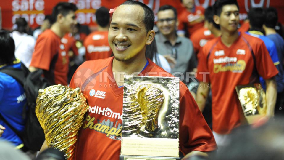 Dikania Wisnu Arki tersenyum lebar memegang trofi dan piala NBL Indonesia musim 2015
