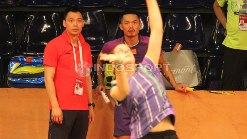 Tunggal putra Tiongkok Lin Dan bersama pelatihnya Ji Xinpeng (belakang) mengamati serius latihan tunggal putri Spanyol, Carolina Marin.