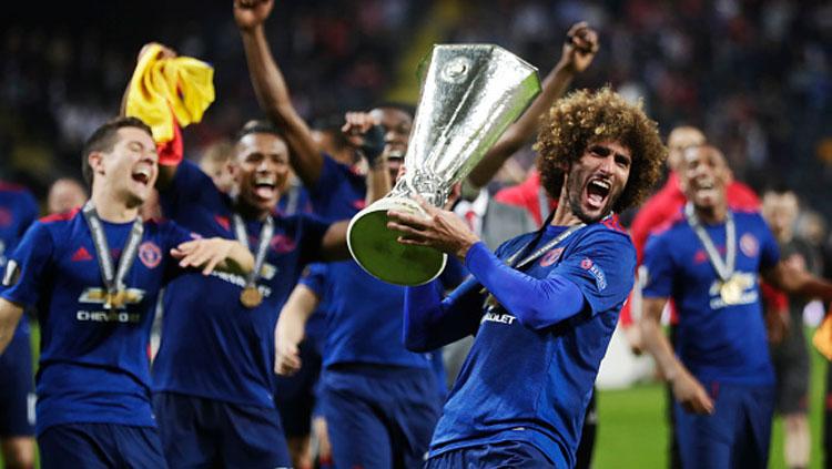 Momen Marouane Fellaini tengah selebrasi bersama trofi Liga Europa musim 2016/17. Copyright: Nils Petter Nilsson/Getty Images