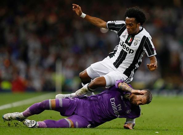 Sergio Ramos menghalau bola yang dikejar oleh Juan Cuadrado. Copyright: ADRIAN DENNIS / Staff