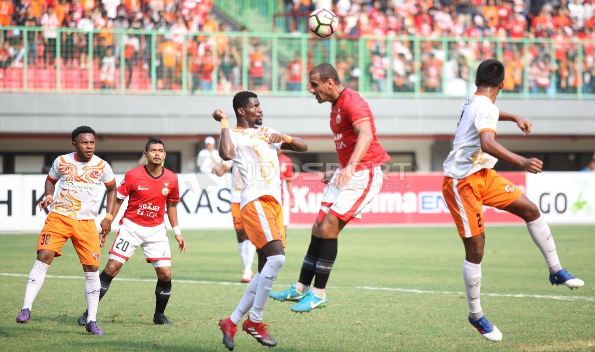 Duel udara antara Bruno Lopes dengan bek Perseru Serui, Boman Bi Irie Aime (tengah). Copyright: Herry Ibrahim/INDOSPORT