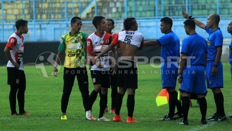 Aksi Deki Rolias Candra yang membuka baju dan diikuti sembilan pemain lainnya, sebagai protes kartu merahnya di menit 15. Copyright: Ian Setiawan/INDOSPORT
