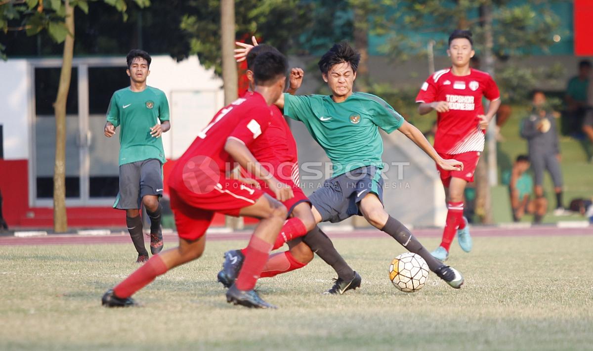 Striker Timnas U-16, Rendy Juliansyah dijaga ketat pergerakannya oleh dua pemain tim Topskor. Copyright: Herry Ibrahi/INDOSPORT.COM