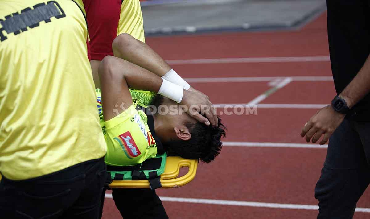 Natshir Mahbuby terkapar dibawa keluar lapangan untuk ditangani tim medis. Copyright: Herry Ibrahim/INDOSPORT