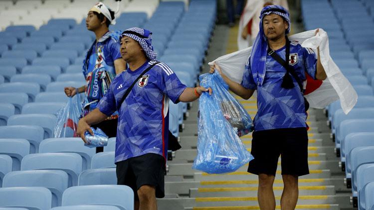 Aksi bersih-bersih dari Fans Jepang di tribun penonton Stadion Al Janoub usai pertandingan melawan Kroasia di babak 16 besar Piala Dunia (Foto:REUTERS/John Sibley). Copyright: REUTERS/John Sibley