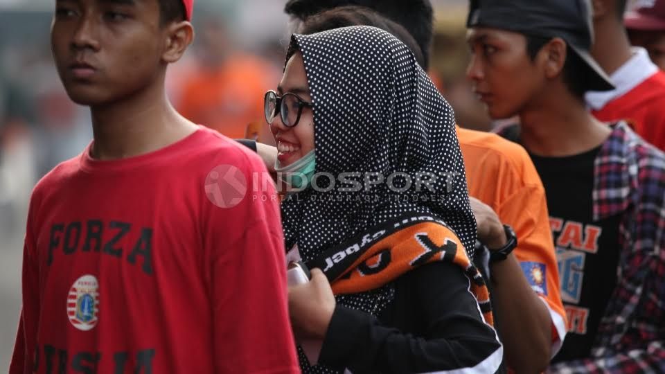Salah seorang Jak Angel berjilbab tersenyum saat mengantri masuk stadion. Copyright: © Herry Ibrahim/INDOSPORT