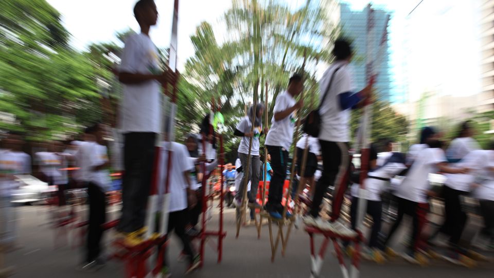 Sejumlah peserta memainkan olahraga tradisional, Egrang. Copyright: © Herry Ibrahim/INDOSPORT