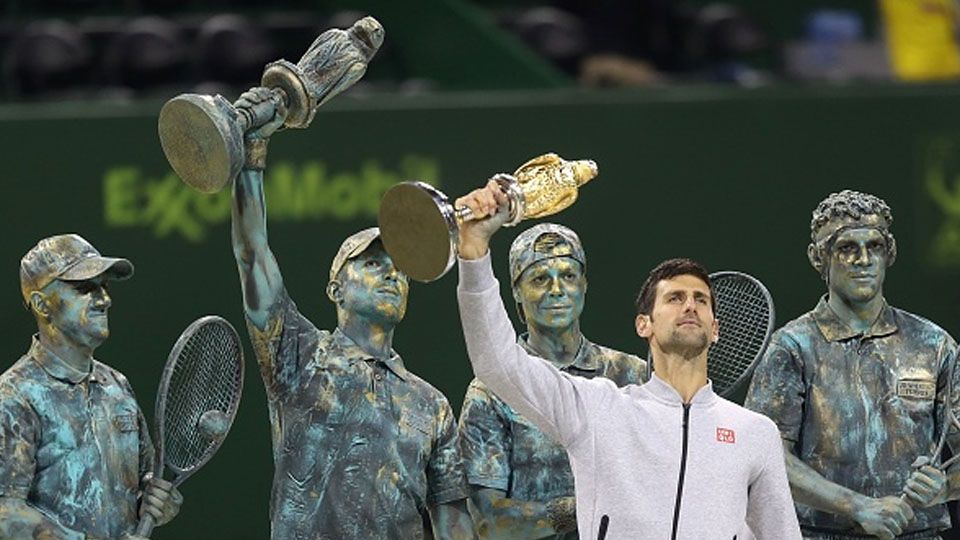 Novak Djokovic saat difoto sebagai pemenang Qatar Open setelah mengalahkan Andy Murray. Copyright: © KARIM JAAFAR/AFP/Getty Images