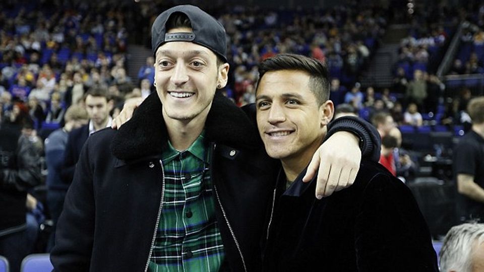 Pasangan bintang Arsenal, Alexis Sanchez dan Mesut Ozil tampak santai saat mereka menyaksikan pertandingan NBA. Copyright: &copy; AP