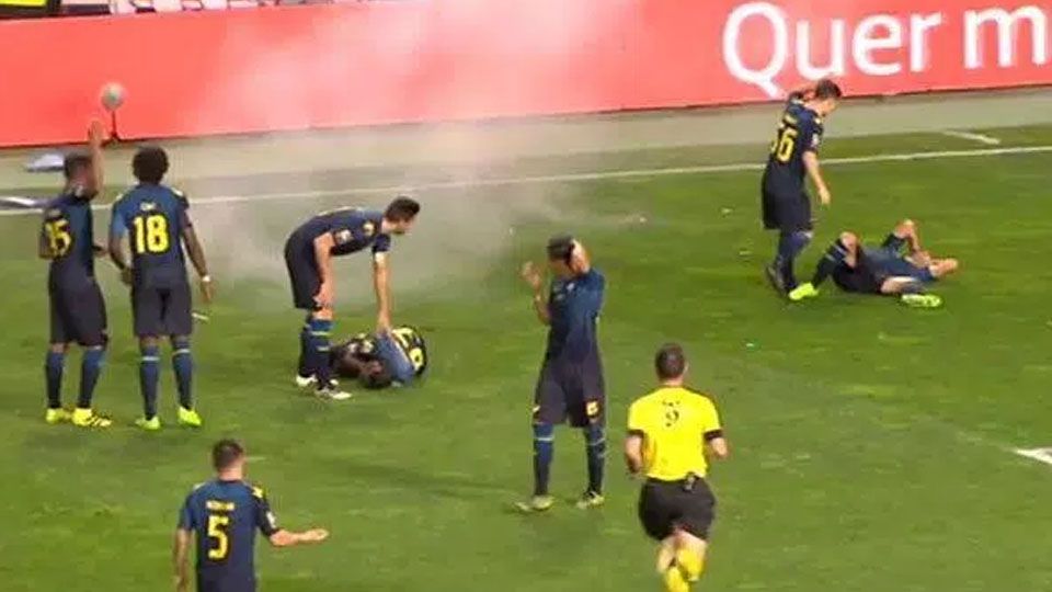 Dua pemain Moreirense terjatuh setelah terkena petasan. Copyright: © thesun.co.uk