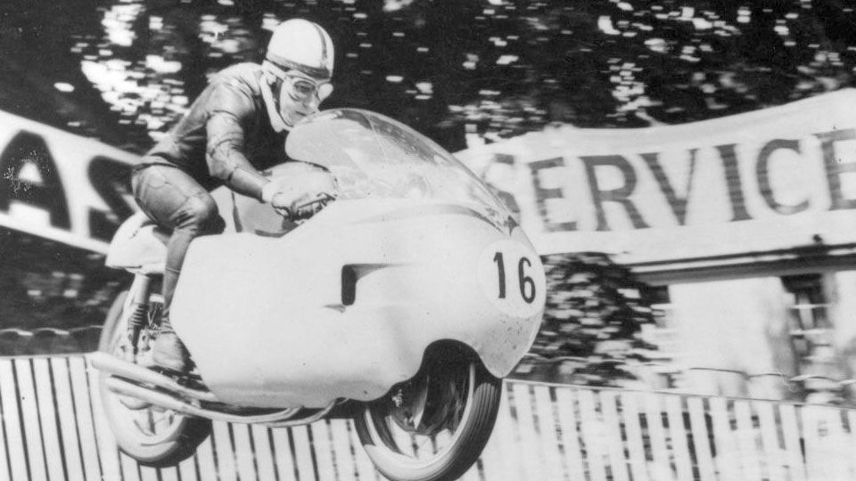 John Surtees ketika sedang mengendarai motor MotoGP. Copyright: © Autosport.