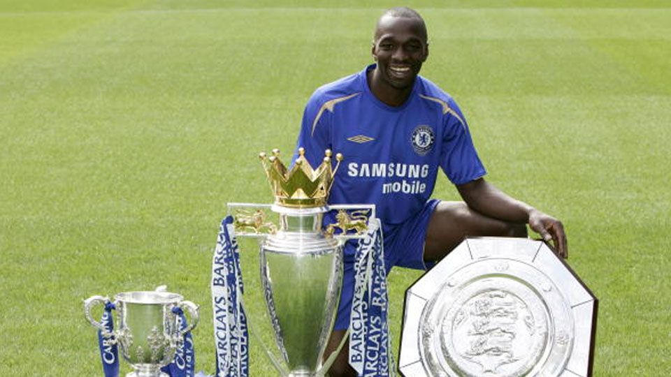 Claude Makelele saat pose bersama trofi Community Shield, Piala Liga Ingris dan Coca Cola League Cup. Copyright: © e Cup trophies (Photo by