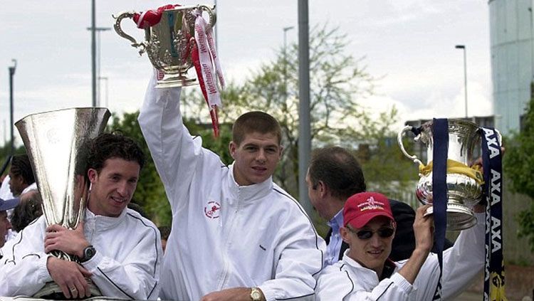 Robbie Fowler, Steven Gerrard, dan Sami Hyypia memamerkan trofi di klub Liverpool. Copyright: © Getty Images