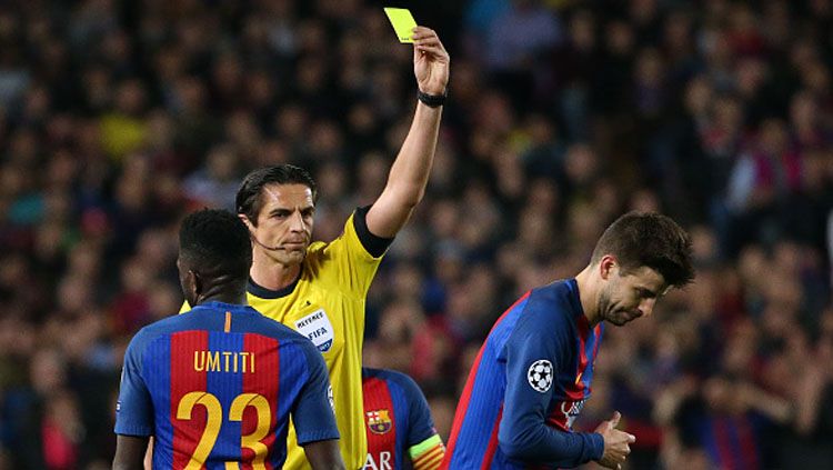 Wasit asal Jerman, Deniz Aytekin, memberi kartu kuning kepada Gerard Pique. Copyright: © Jean Catuffe/Getty Images