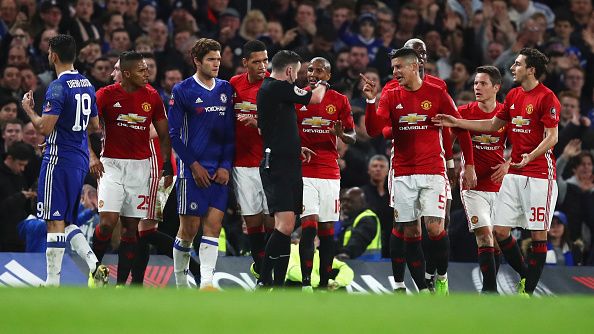 Para pemain Manchester United kala mengerubungi wasit Michael Oliver, pasca kartu merah Ander Herrera. Copyright: © Julian Finney/Getty Images