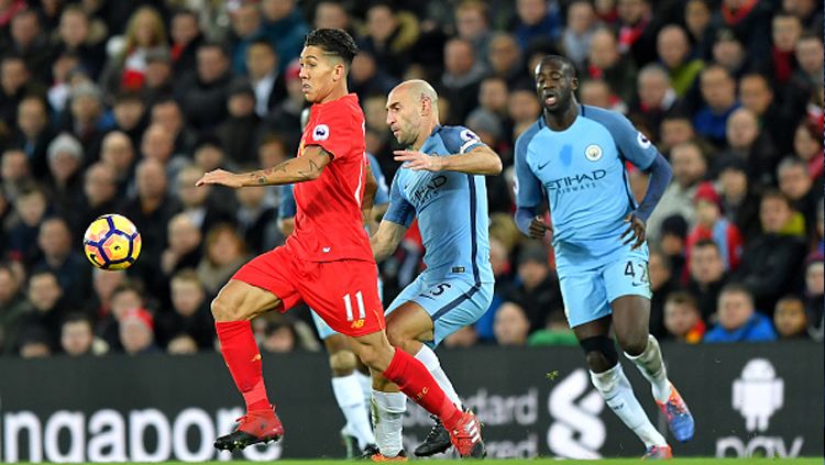 Firmino mencoba menghindari penjagaan pemain Manchester City. Copyright: © Dave Howarth/PA Images via Getty Images