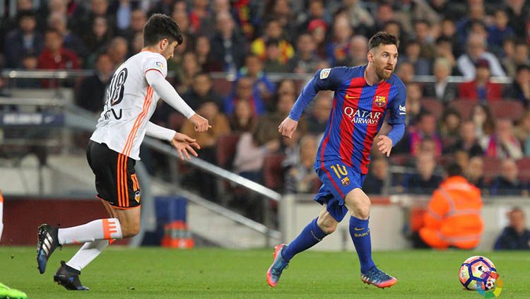 Lionel Messi mencoba melewati hadangan pemain Valencia. Copyright: © Twitter @LaLiga