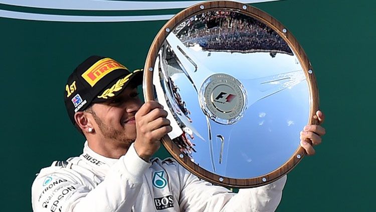 Momen Lewis Hamilton saat angkat trofi juara kedua di Australia. Copyright: &copy; MAL FAIRCLOUGH/AFP/Getty Images