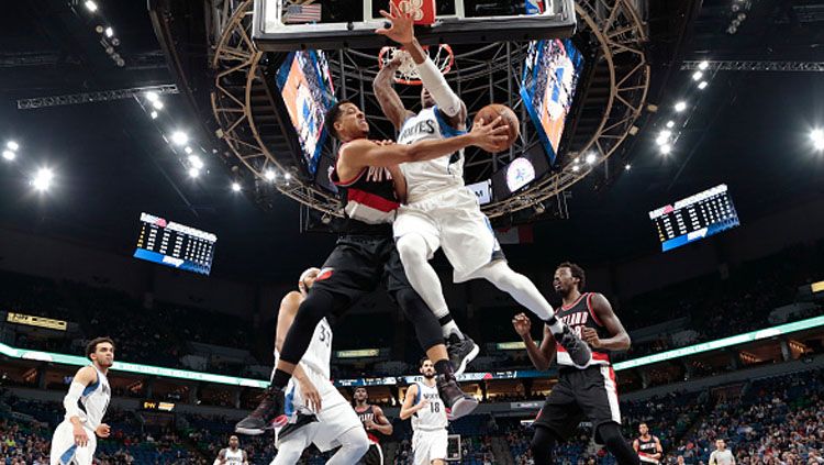 Pemain Portland Trail Blazers, C.J. McCollum (kiri) mendapat perlawanan dari pemain Minnesota Timberwolves. Copyright: &copy; Jordan Johnson/NBAE via Getty Images