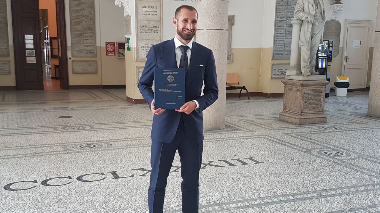 Giorgio Chiellini yang berpose bersama dengan tesisnya, pasca sidang. Copyright: &copy; Juventus